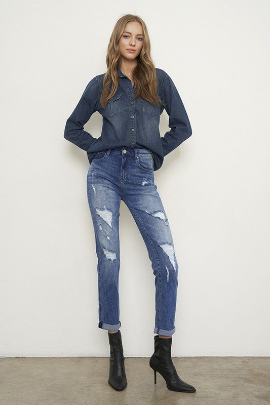 Medium wash distressed girlfriend jeans with a slim fit, mid-rise waist, button closure, and ankle-length cut.