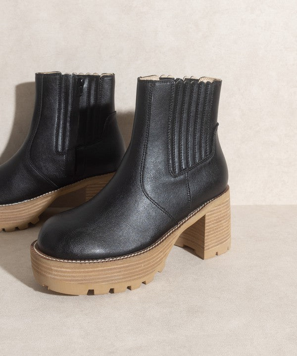 Black pull-on boots with a rounded toe, chunky platform, and high-quality elastic gussets.