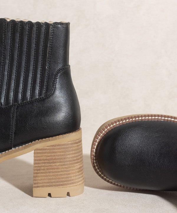 Black pull-on boots with a rounded toe, chunky platform, and high-quality elastic gussets.