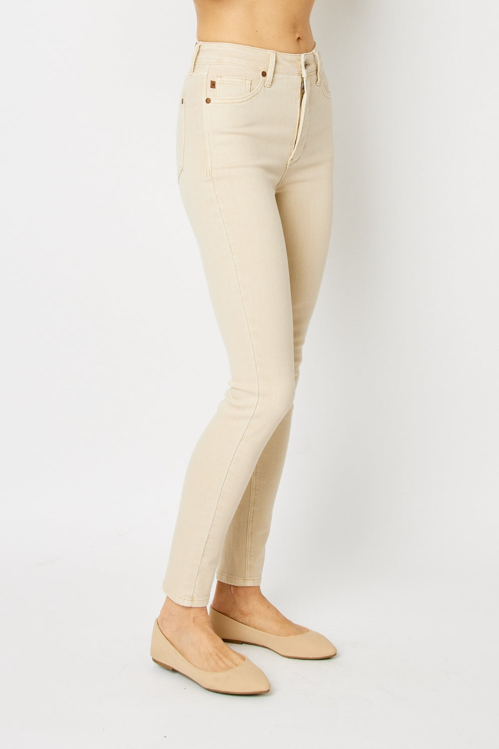 High-rise skinny jeans in bone with tummy control panel and zip fly. Slightly stretchy for comfort.