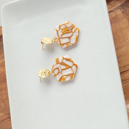 Roxy Hexagon Earrings in warm pumpkin spice color with acrylic finish, displayed on white background.