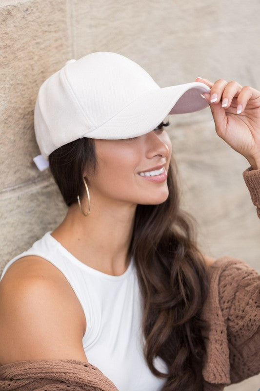 Woman wearing cream velour ball cap, side profile highlighting fall texture.