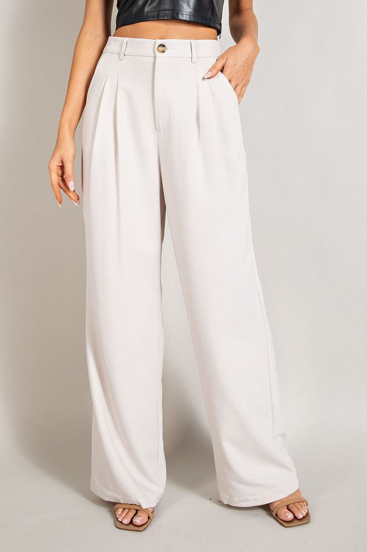 Oatmeal, straight-leg pants with pleats, pockets, and a zip fly, with a relaxed, loose fit.