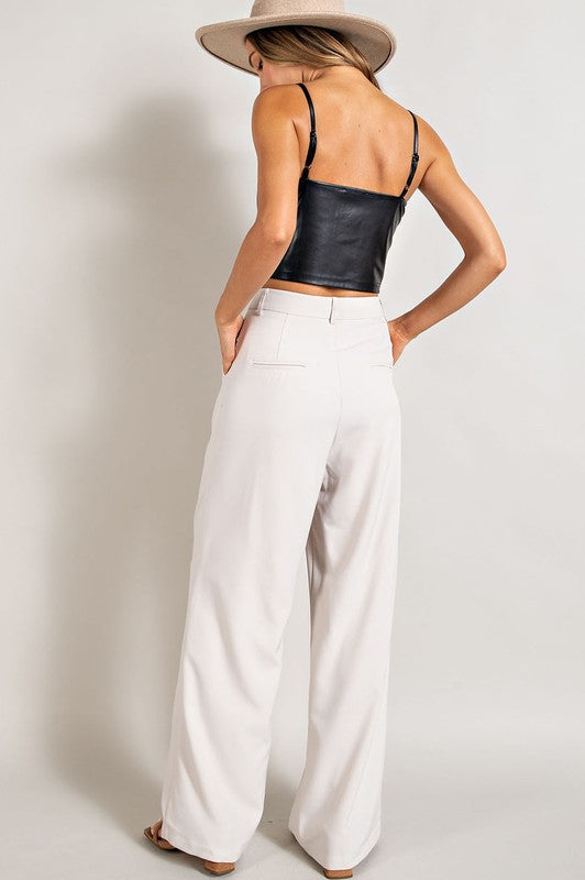 Oatmeal, straight-leg pants with pleats, pockets, and a zip fly, with a relaxed, loose fit.