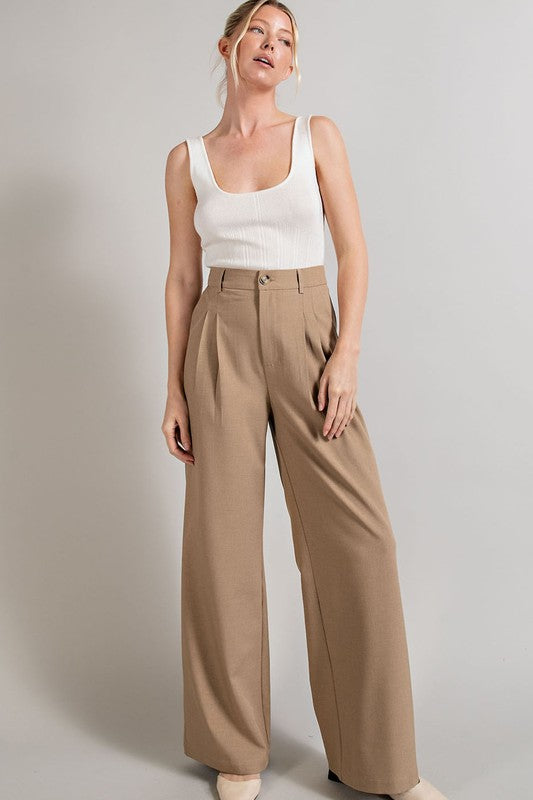 Coco, straight-leg pants with pleats, pockets, and a zip fly, with a relaxed, loose fit.