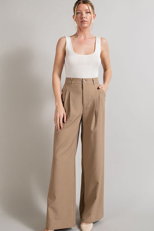 Coco, straight-leg pants with pleats, pockets, and a zip fly, with a relaxed, loose fit.