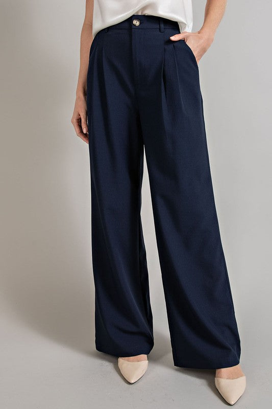 Navy, straight-leg pants with pleats, pockets, and a zip fly, with a relaxed, loose fit.