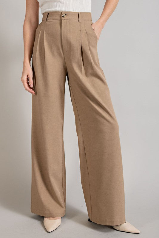 Coco, straight-leg pants with pleats, pockets, and a zip fly, with a relaxed, loose fit.