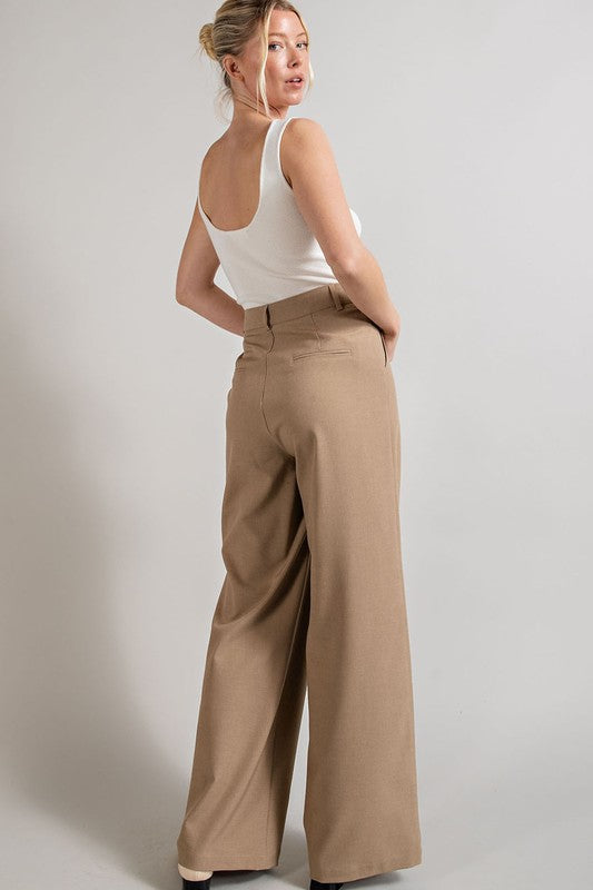 Coco, straight-leg pants with pleats, pockets, and a zip fly, with a relaxed, loose fit.