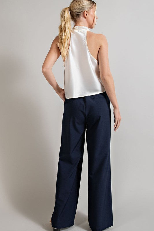 Navy, straight-leg pants with pleats, pockets, and a zip fly, with a relaxed, loose fit.