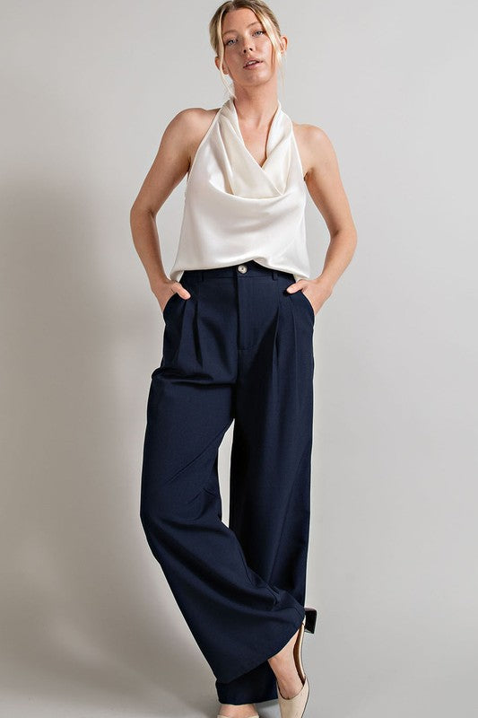 Navy, straight-leg pants with pleats, pockets, and a zip fly, with a relaxed, loose fit.