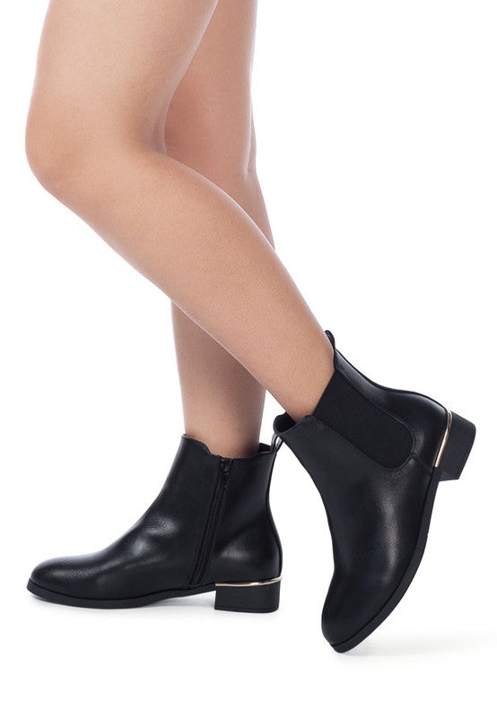 Model wearing black Yacht Winter Ankle Boots styled with bare legs.