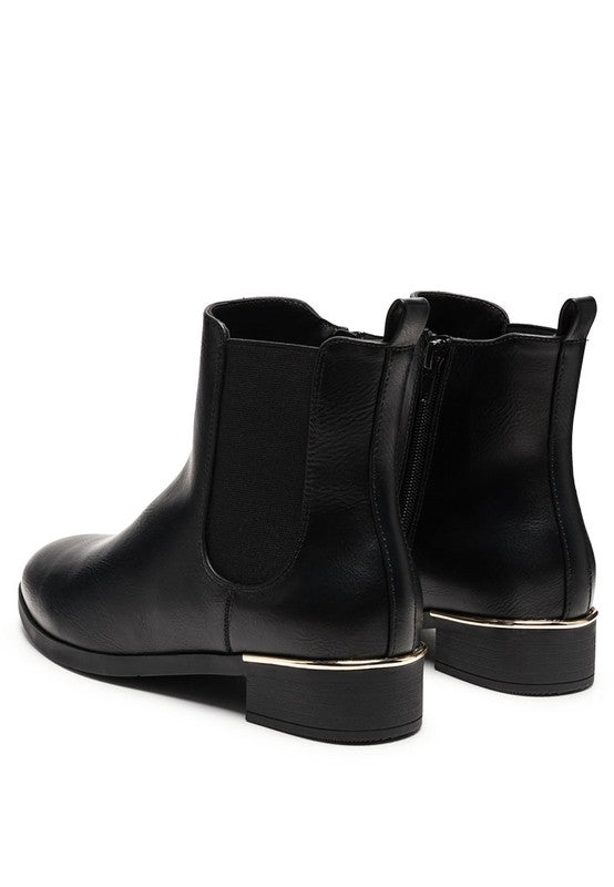 Back angled view of black Chelsea boots with gold detail on heel.