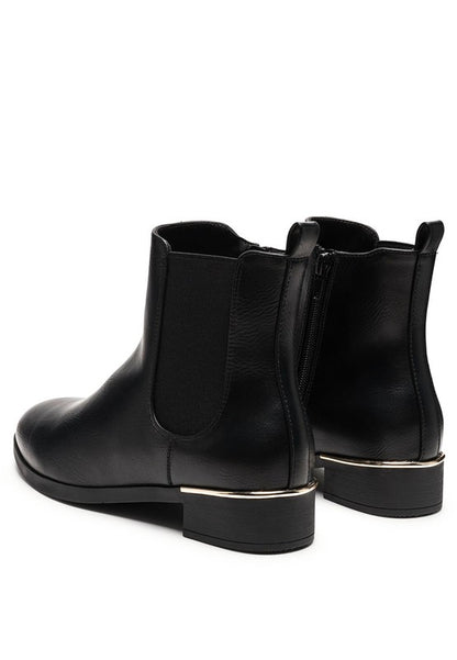 Back angled view of black Chelsea boots with gold detail on heel.