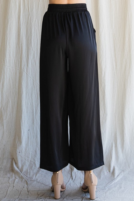 Back view of Cita Wide Leg Bottoms highlighting wide-leg cut and smooth high-rise waist.