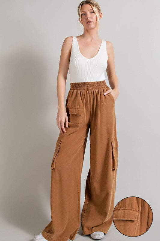 Wide-leg mineral-washed cargo pants in a clay color with an elastic waist and multiple pockets.