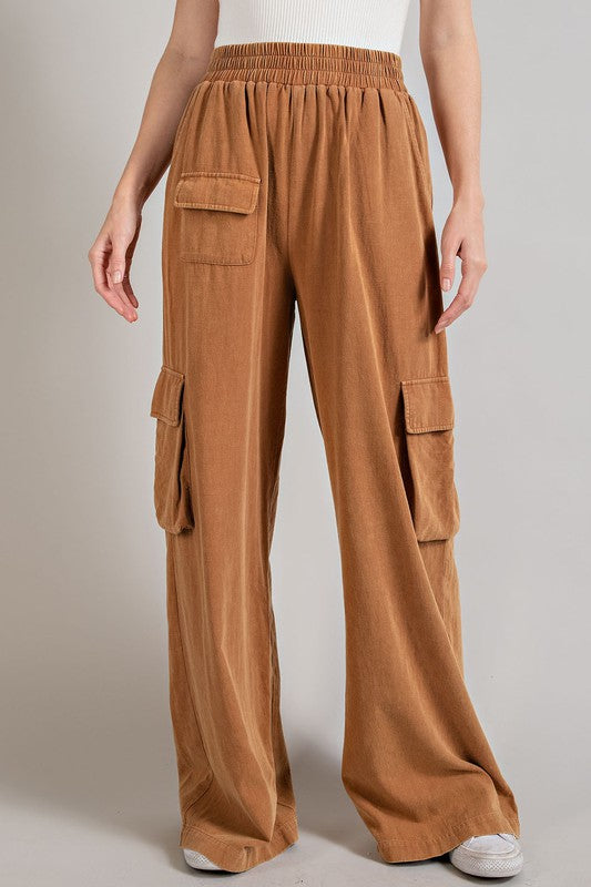 Wide-leg mineral-washed cargo pants in a clay color with an elastic waist and multiple pockets.