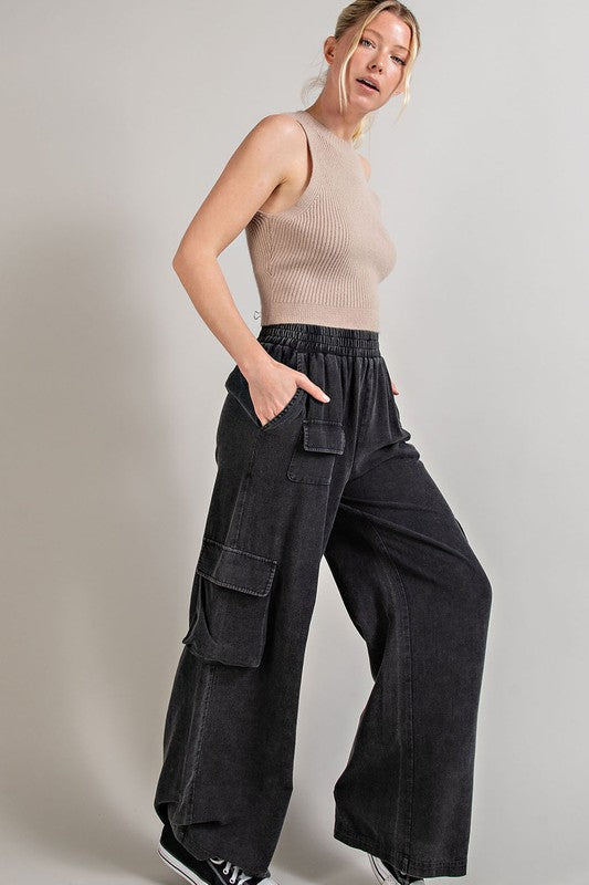 Wide-leg mineral-washed cargo pants in ash gray with an elastic waist and multiple pockets.