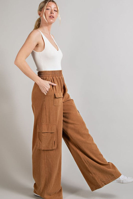 Wide-leg mineral-washed cargo pants in a clay color with an elastic waist and multiple pockets.