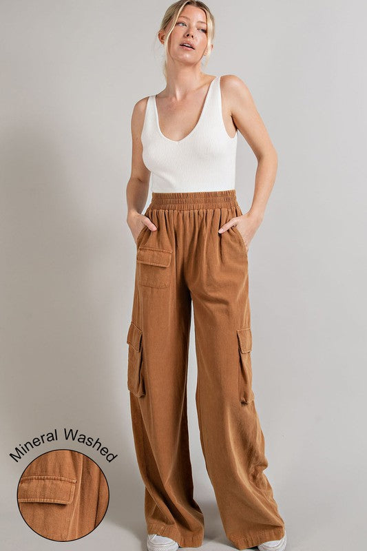 Wide-leg mineral-washed cargo pants in a clay color with an elastic waist and multiple pockets.