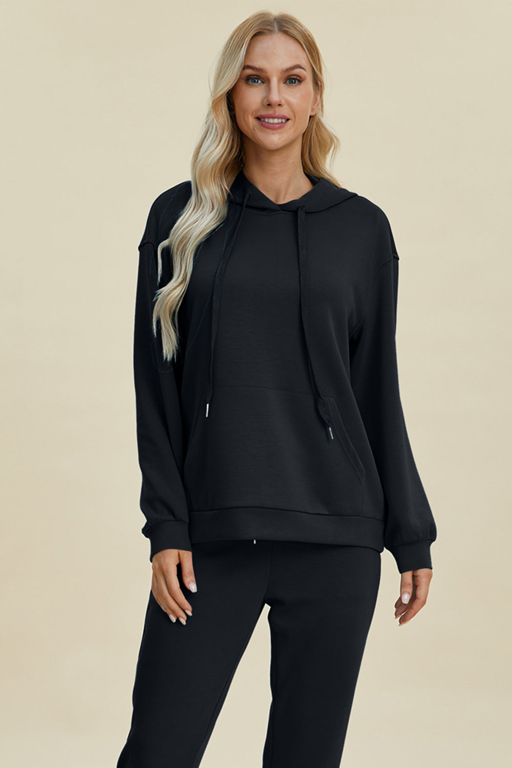 Black long sleeve hoodie with kangaroo pocket, featuring a drawstring hood andrelaxed fit.