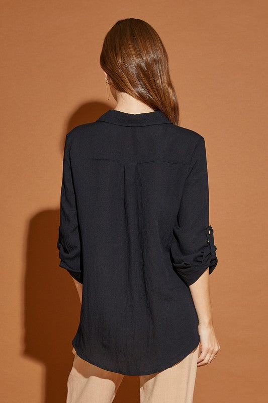 Black classic woven blouse with a V-neckline, button-down front, and Henley style. Features long sleeves, pockets, and a relaxed fit.