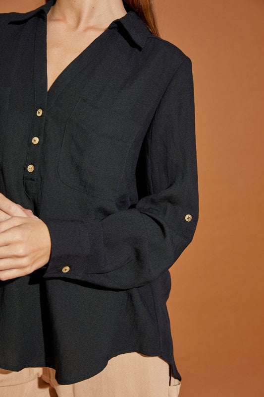 Black classic woven blouse with a V-neckline, button-down front, and Henley style. Features long sleeves, pockets, and a relaxed fit.