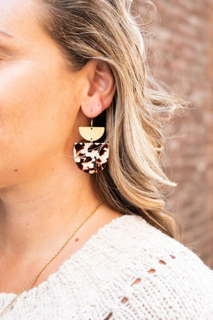Woman wearing Harper Cowhide Print Earrings with gold-plated hooks, bold cowhide pattern visible.