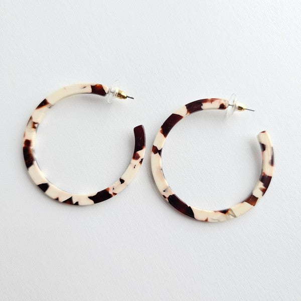 Cowhide patterned hoop earrings made from lightweight acrylic with a hypoallergenic stainless steel stud, 2" diameter.