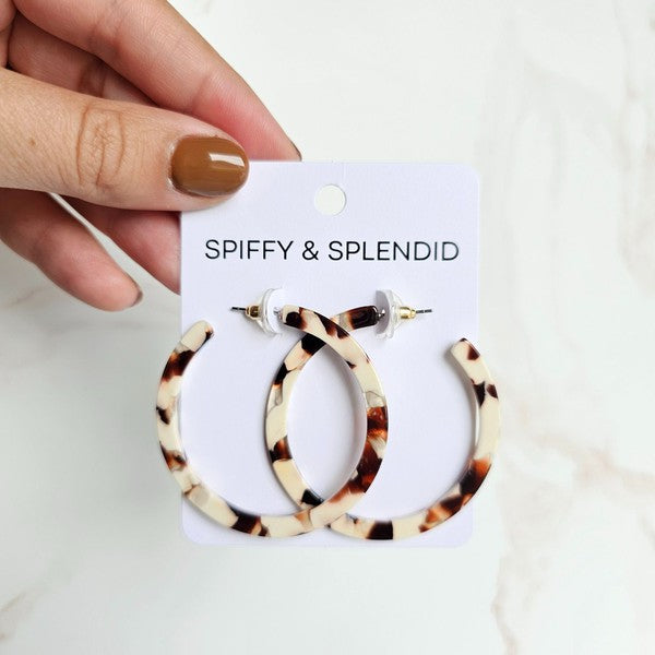 Cowhide patterned hoop earrings made from lightweight acrylic with a hypoallergenic stainless steel stud, 2" diameter.