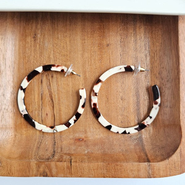 Cowhide patterned hoop earrings made from lightweight acrylic with a hypoallergenic stainless steel stud, 2" diameter.