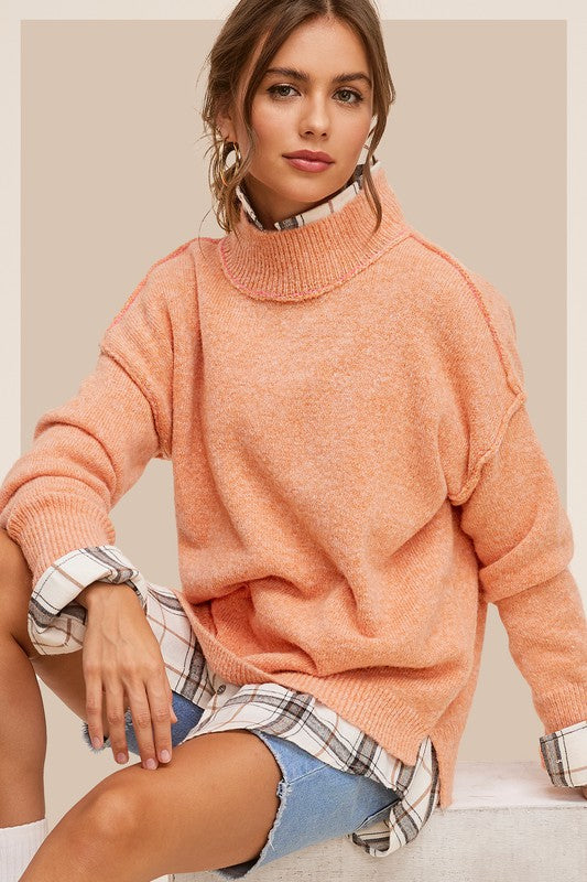 Cozy knit mock neck sweater in pumpkin, featuring long sleeves, drop shoulders, and an oversized fit.