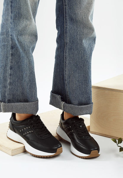 Model wearing black Athion Studded Leather Sneakers with lace-up design