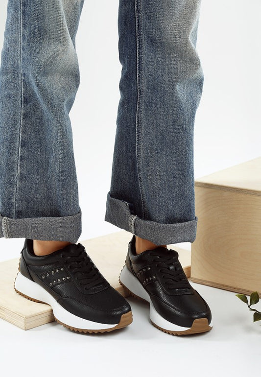 Model wearing black Athion Studded Leather Sneakers with lace-up design