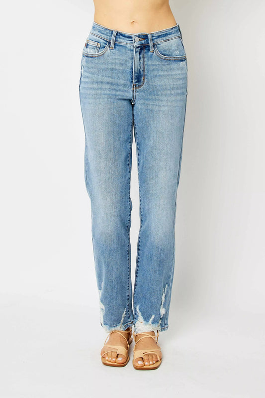 Model wearing Judy Blue Estee high waist straight jeans in medium wash with raw hem edge.