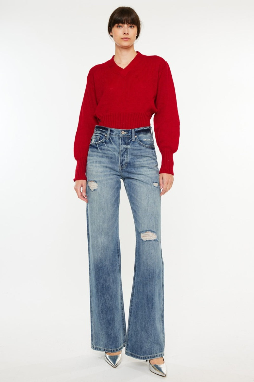 Distressed high-rise bootcut jeans with pockets and a slightly stretchy, washed fabric, offering a retro-chic style.