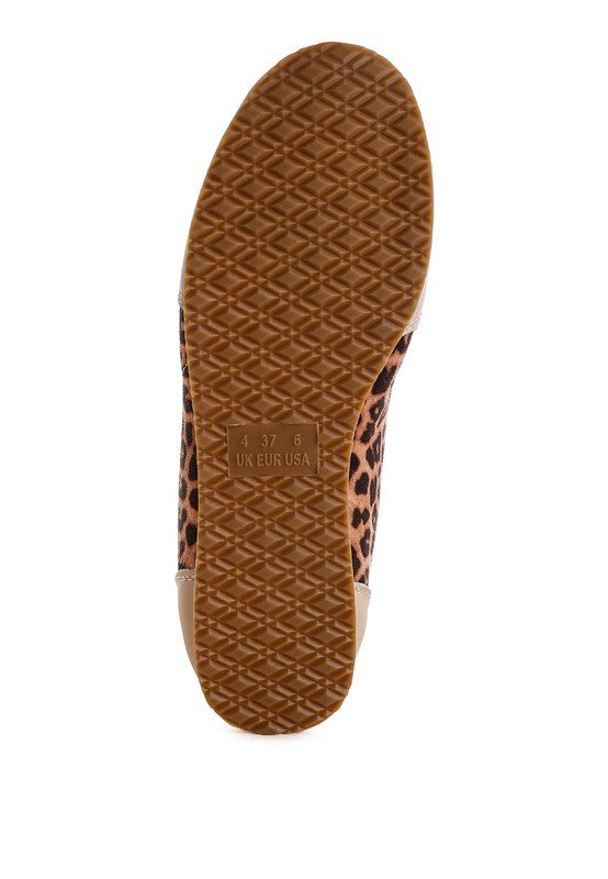 Bottom view of leopard print and beige genuine leather sneakers showing textured TP rubber sole.