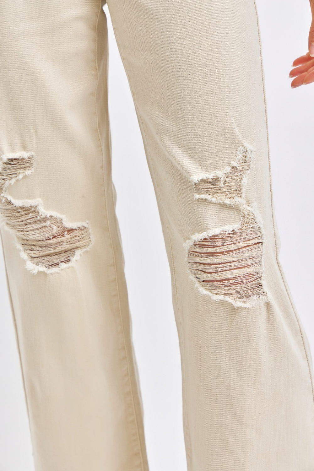 Bone-colored high-waisted wide-leg jeans with distressed details pockets, stretch denim with zip fly.