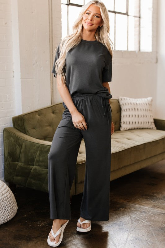 Woman wearing Dallas Two-Piece Set in dark gray with crew tee and wide-leg drawstring pants
