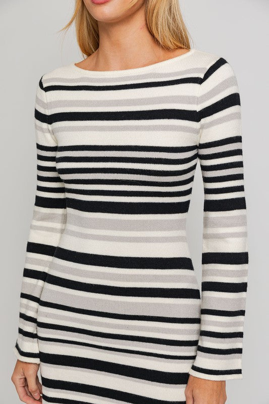 Black and white striped sweater dress with a boat neckline, long bell sleeves, and a mini length.