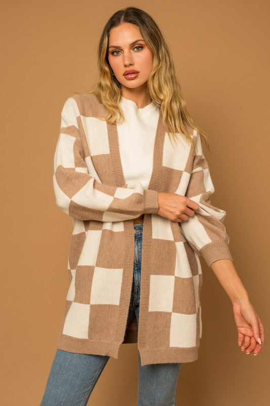 A long open-front cardigan made of knit fabric with a taupe and white checker pattern. It features long sleeves, side pockets, and a relaxed, medium long length