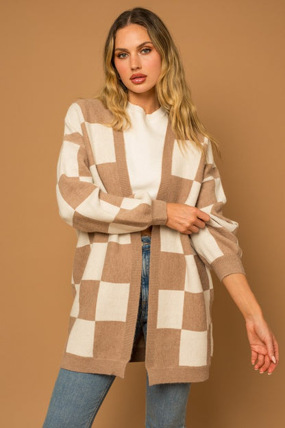 A long open-front cardigan made of knit fabric with a taupe and white checker pattern. It features long sleeves, side pockets, and a relaxed, medium long length
