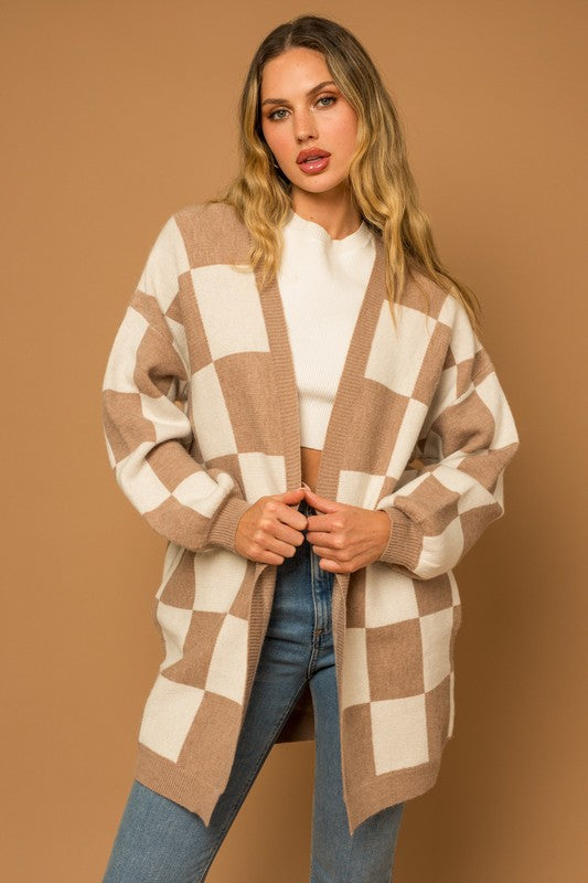 A long open-front cardigan made of knit fabric with a taupe and white checker pattern. It features long sleeves, side pockets, and a relaxed, medium long length