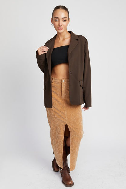 Model wearing Rasha Corduroy Mid Skirt With Front Slit, styled with blazer and boots.