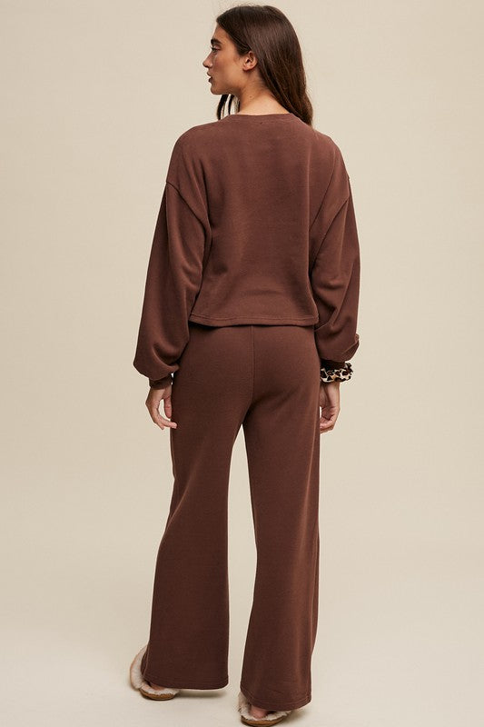 Cozy mocha knit sweat top with round neck and long sleeves paired with wide-leg mocha pants featuring an elastic waist and pockets.