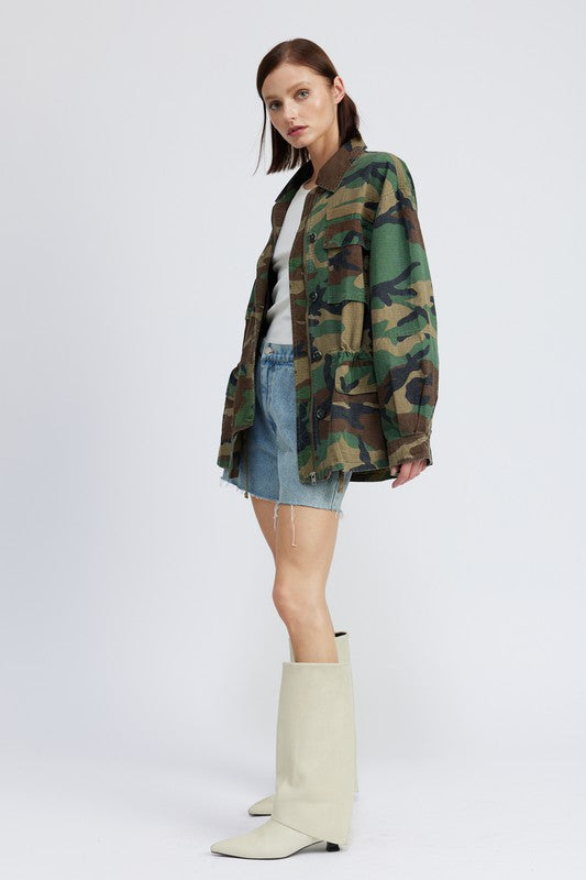 Oversized camo jacket with a collared neckline, long sleeves, and practical pockets. Made of 100% cotton with zipper and button closures.