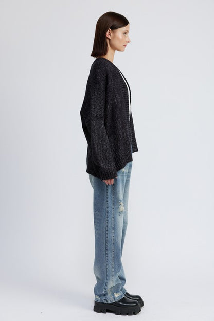 Model in side view wearing Elistina Oversized Cardigan with drop shoulders.