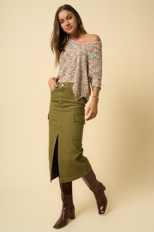 Olive green denim cargo midi skirt with a front slit and seven functional pockets. Features a button closure and regular fit.