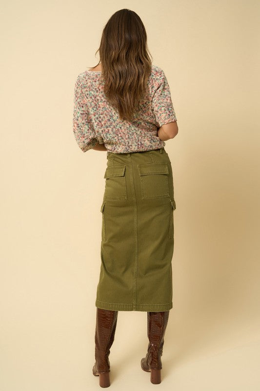 Olive green denim cargo midi skirt with a front slit and seven functional pockets. Features a button closure and regular fit.