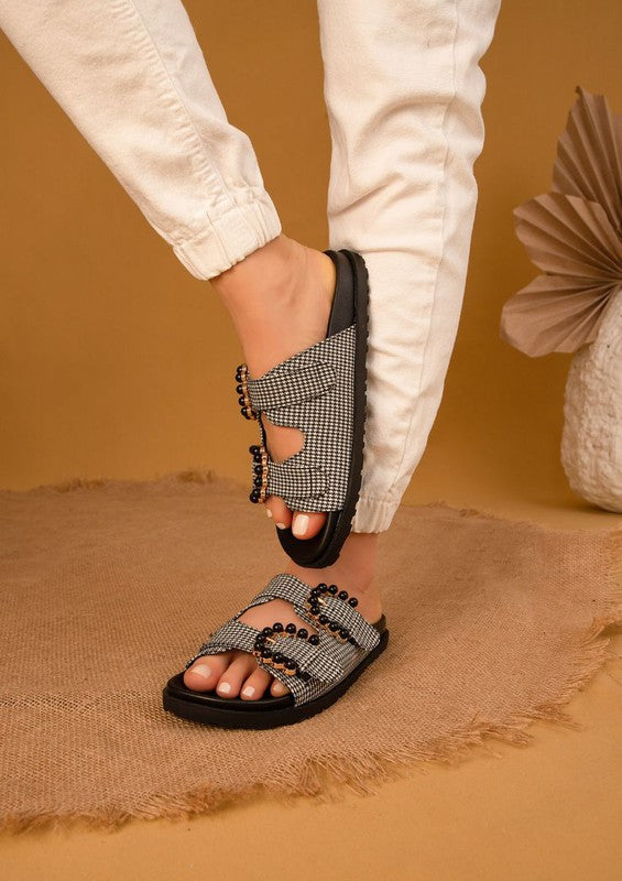 Black Kelly Houndstooth Slides showing houndstooth pattern and beaded buckle detail.